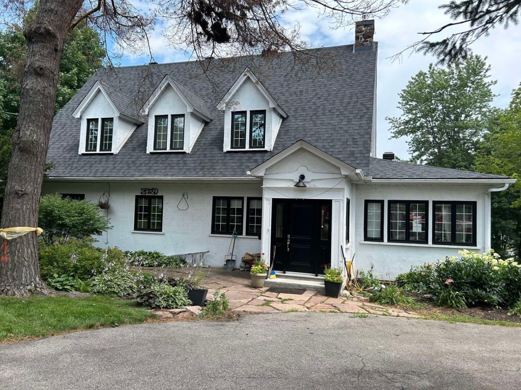 Maison blanche à trois lucarnes avec toiture neuve en bardeaux gris